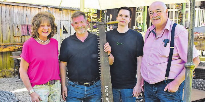 Alt und neu vereint: Heidi Mosimann (links) und Oskar «Oski» Urech (rechts) übergeben die «Moosersagi» symbolisch mit der Säge an ihre Nachfolger Sandro Boll und Martin Röthlisberger, die das Gasthaus Ende 2026 übernehmen. (Bild: Raphael Nadler)