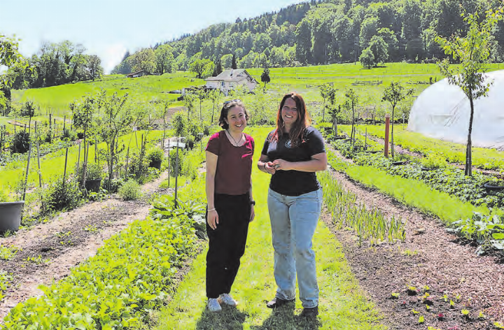 Tilika Chamberlin (rechts im Bild) bei der wissenswerten Führung mit einer aufmerksamen Besucherin, zwischen Rüebli, Kräuter und co.