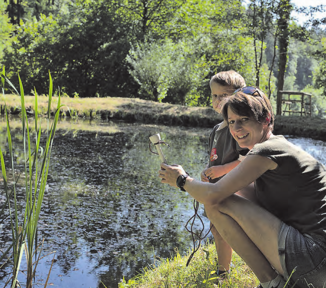 Mutter mit Sohn am Weiher, wo die vielen Amphibien leben. Mutter mit Sohn am Weiher, wo die vielen Amphibien leben.
